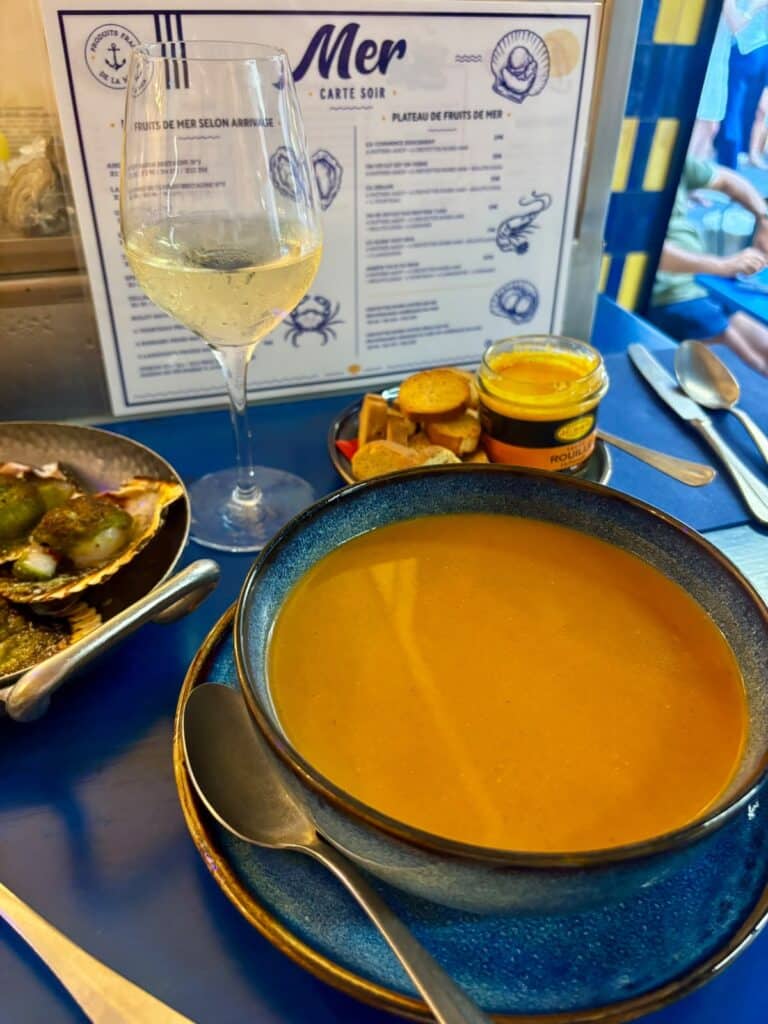 An orange soup in a blue bowl.