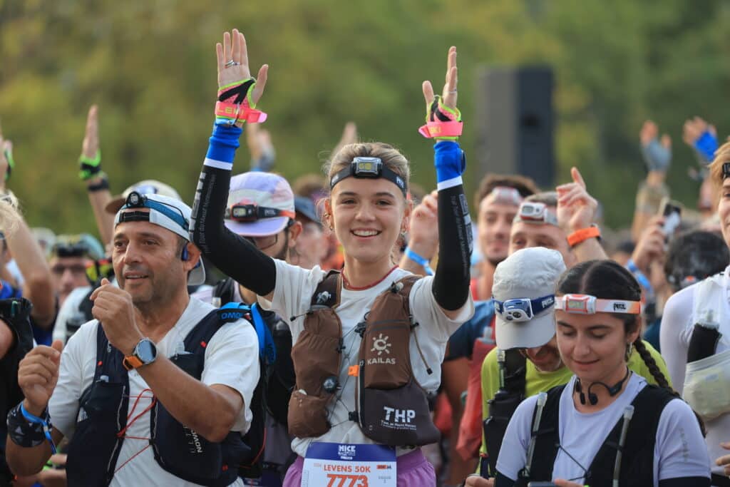 A participant in the UTMB Nice 2026 claps her hands to build excitement before the start.