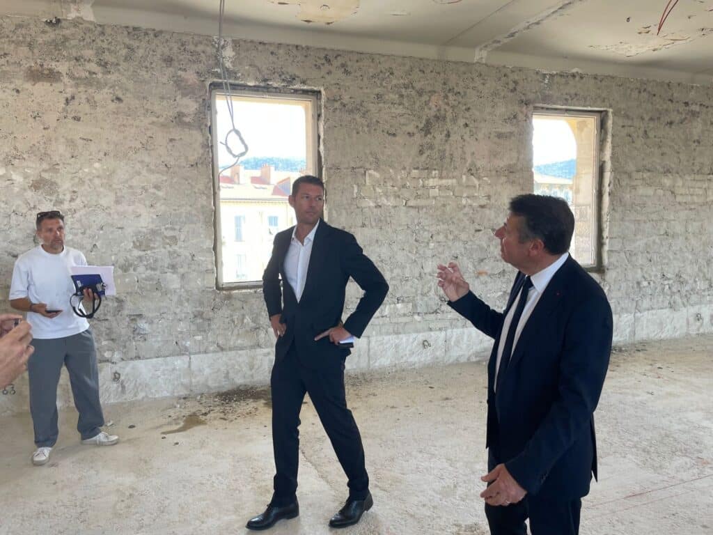 Christian Estrosi standing in a suit in the middle of the construction site for the new boarding house of Lycée Masséna