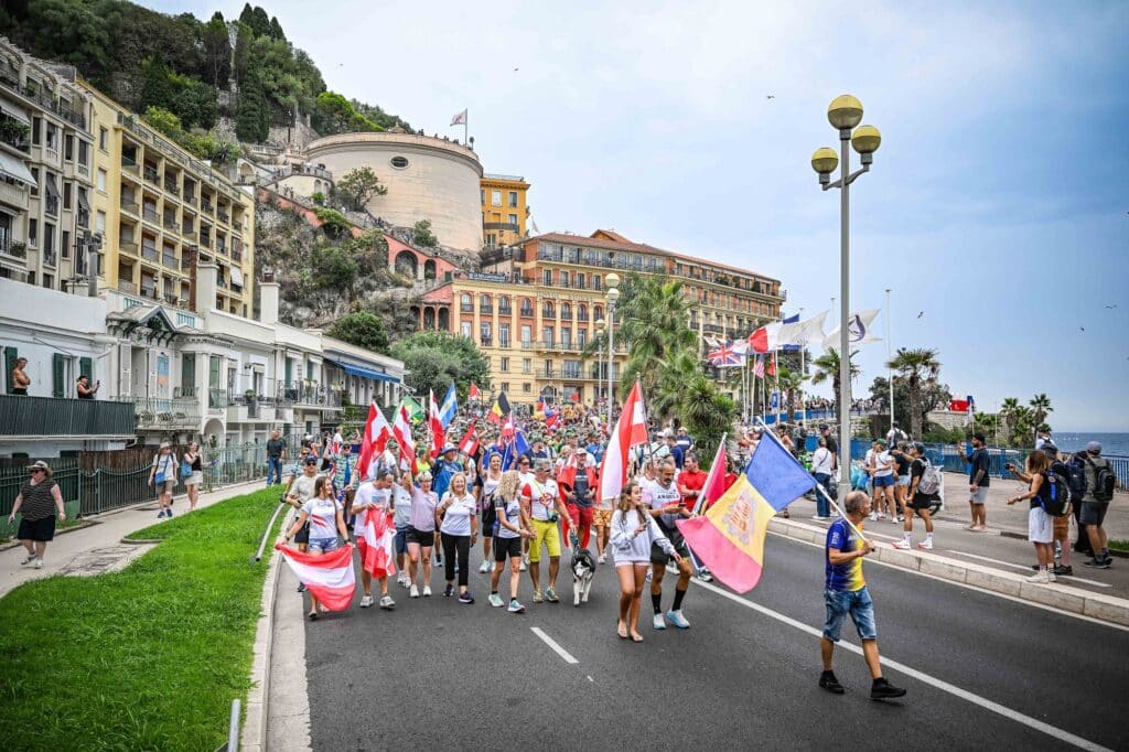 Spectators create atmosphere along the course with flags.