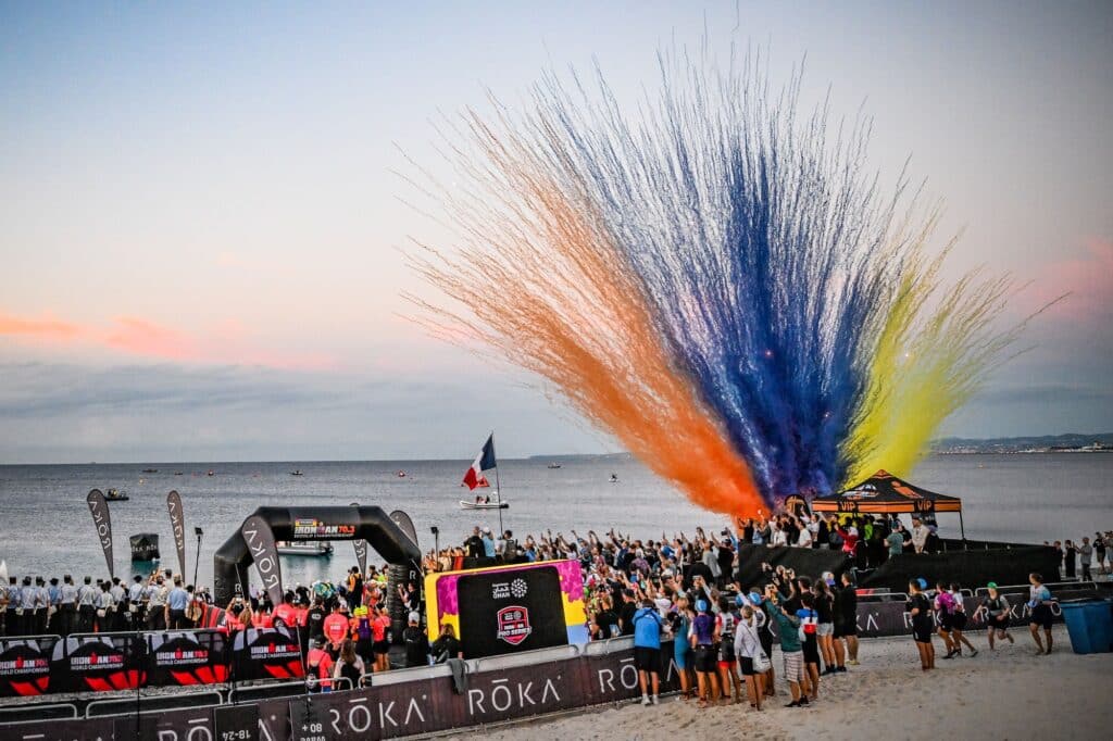 A daytime fireworks display with red, orange, yellow, and blue colors.