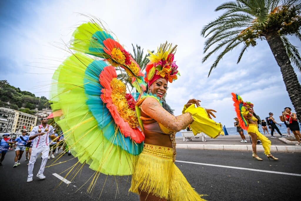 A dancer in a colorful Brazilian costume performs on the Nice Ironman course