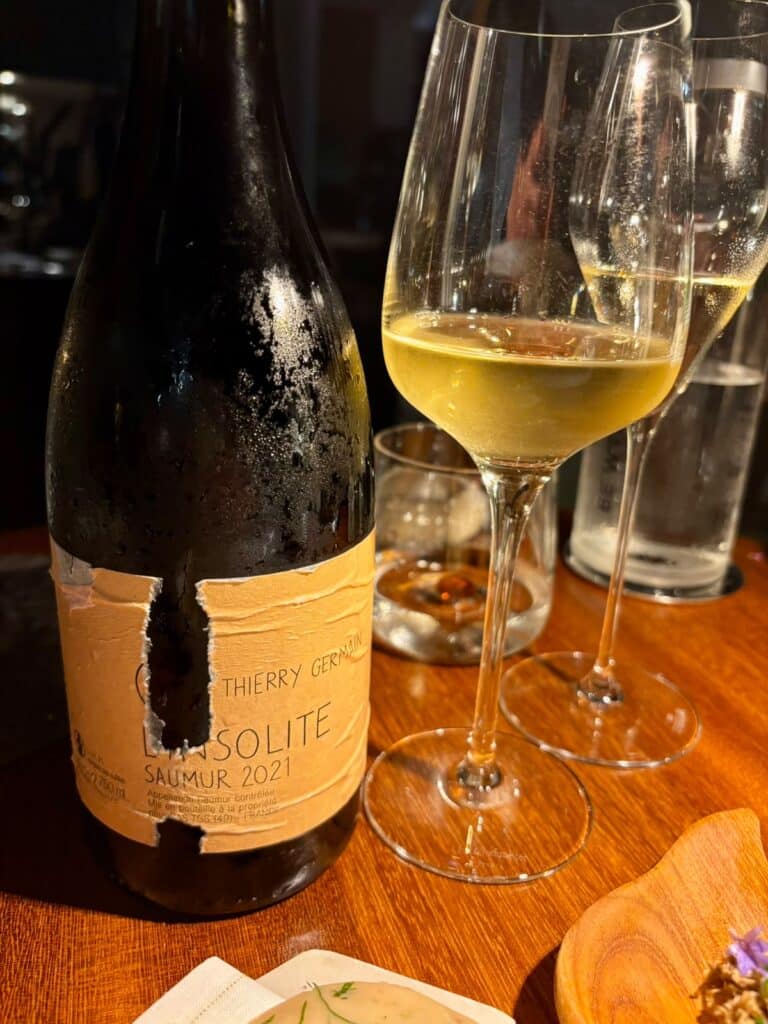 A bottle and a glass of white wine.