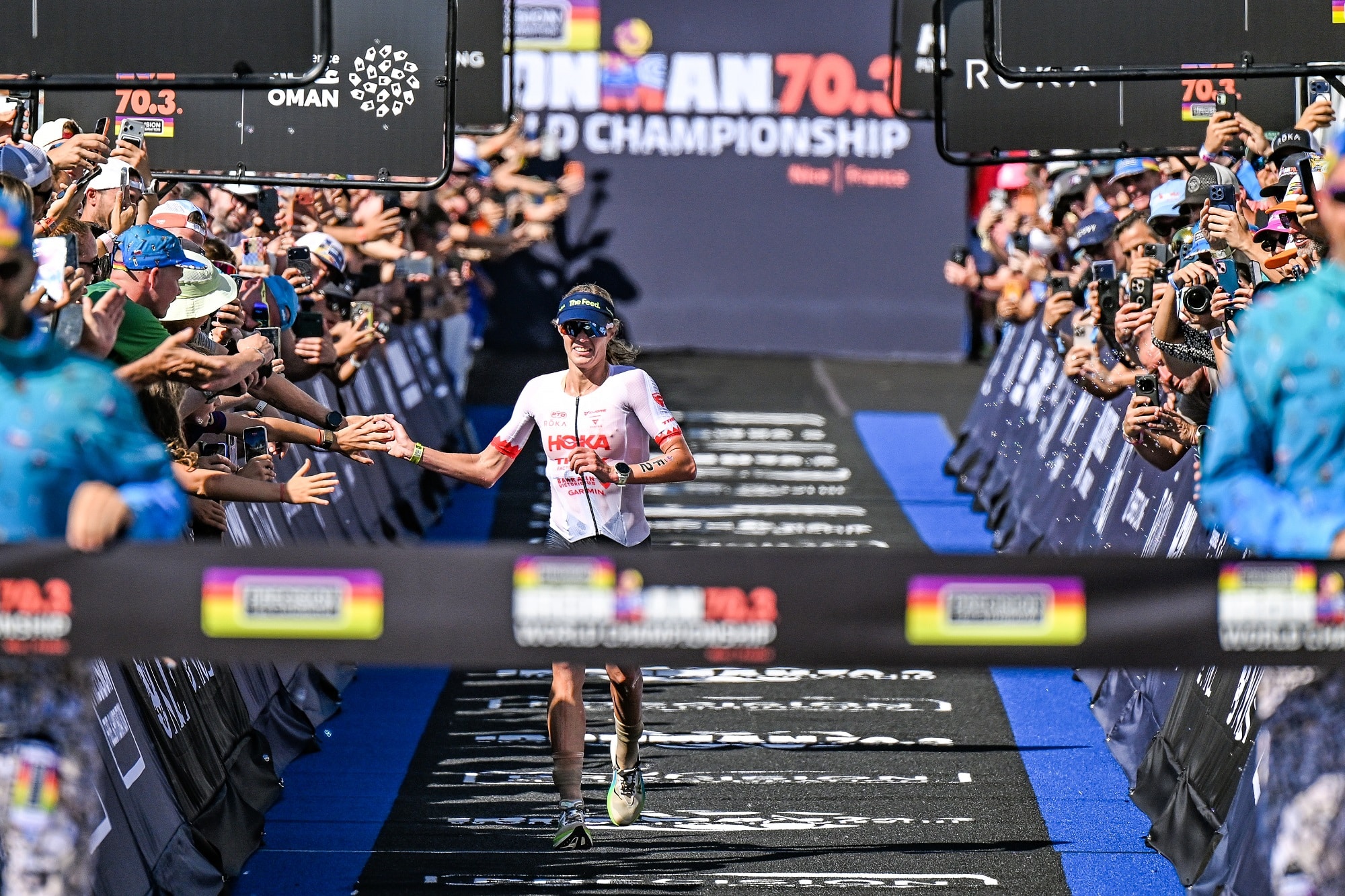 The winner of the 2026 Ironman World Championship edition at the finish line high-fives spectators along the course.