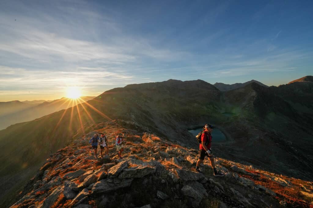 A sunset over the mountains with runners passing by.
