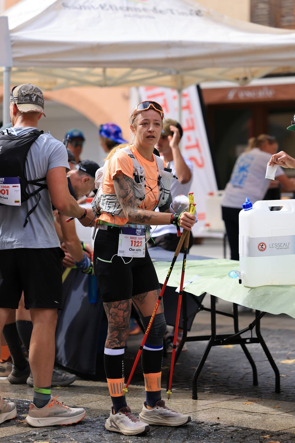 A female runner hydrates and gets food to eat during a refueling stop.