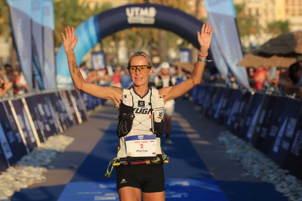 The winner of the 100M at Nice Côte d'Azur by UTMB Martina Klancnik Potrc raises her arms at the finish line.