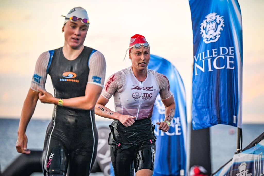 Two athletes come out of the water one behind the other.