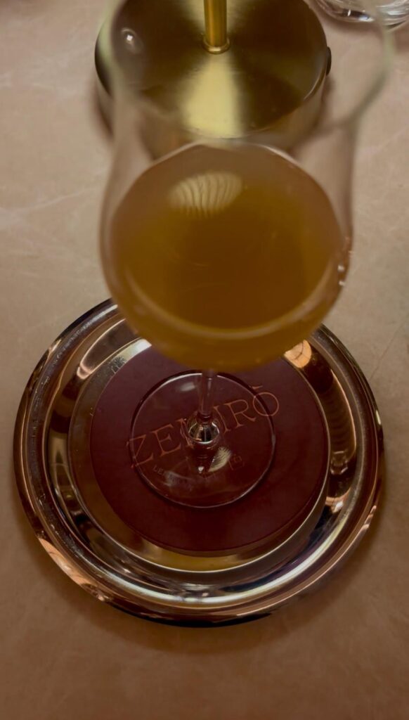 A glass of wine placed on a Zeniro engraved coaster.