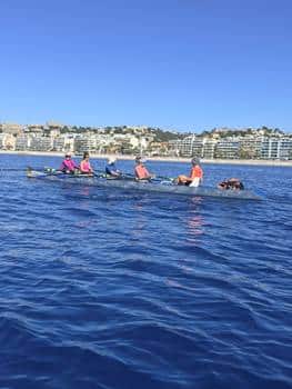 Women on the sea in a rowing boat rowing.
